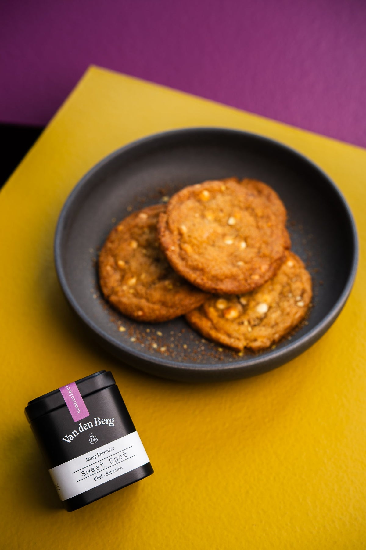 White Chocolate Lemon Cookies in einer dunklen Schale neben einer Dose Sweet Spot von Van den Berg