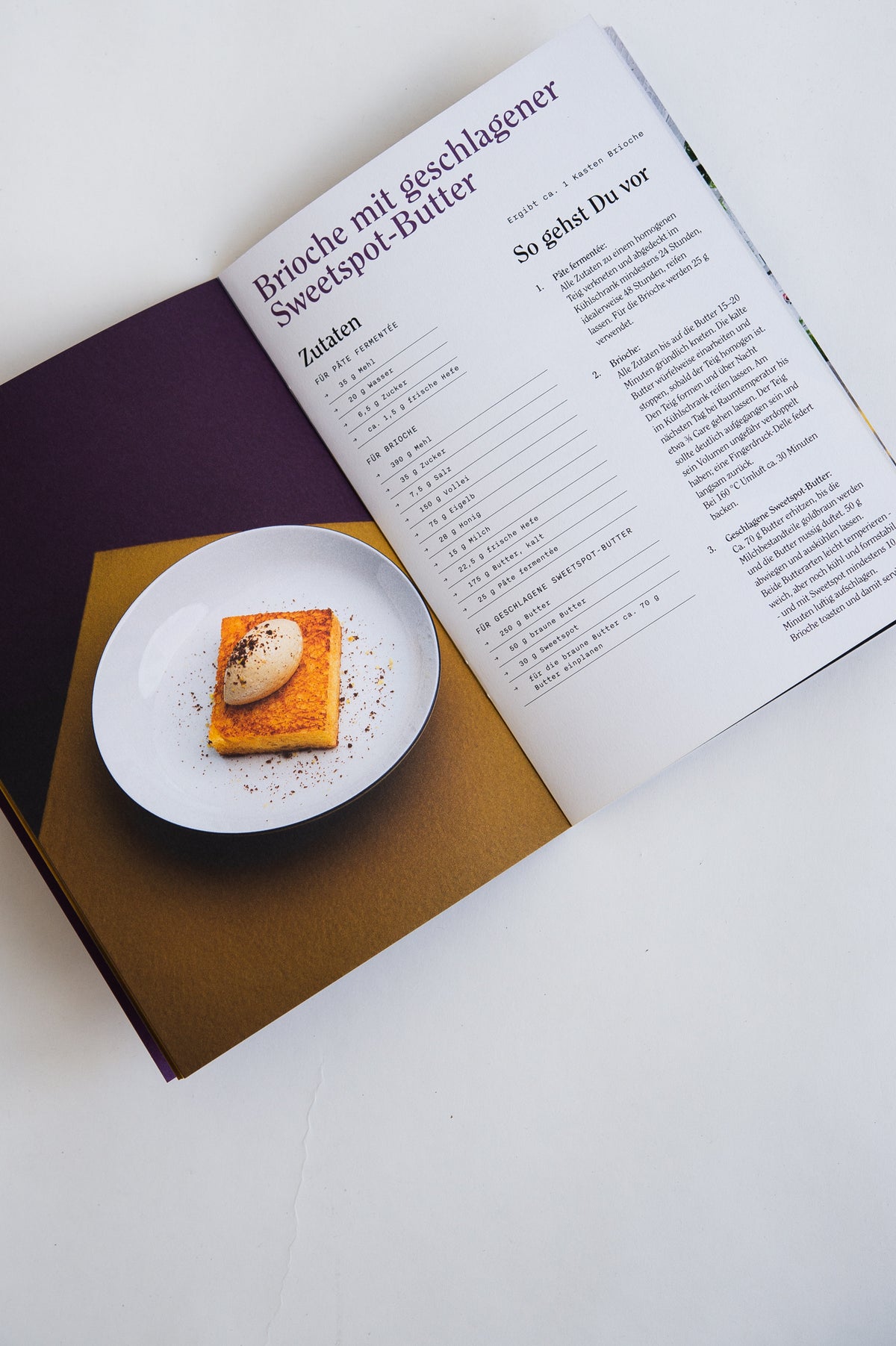 Aufgeschlagenes Rezeptheft mit Brioche und geschlagener Sweet-Spot-Butter.